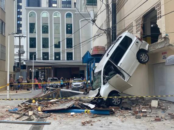 Carro atravessa parede de prédio em Balneário Camboriú, cai na rua, e mulher fica ferida
