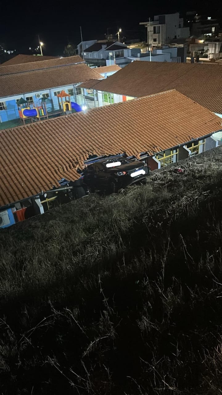 Carro fica suspenso em telhado de escola após saída de pista em Santa Catarina