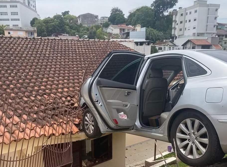 Carro dispara com criança sozinha dentro e fica suspenso após atingir cerca, em Erechim